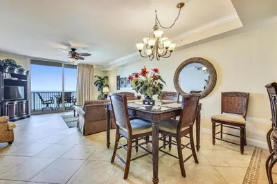 a dining room with a table with chairs and a mirror at Tidewater Beach Resort #508 by Book That Condo in Panama City Beach
