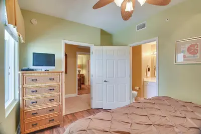 a bedroom with a bed and a dresser with a television at Tidewater Beach Resort #2014 by Book That Condo in Panama City Beach