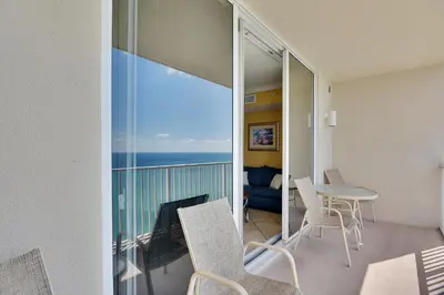a room with a balcony with a view of the ocean at Tidewater Beach Resort #2014 by Book That Condo in Panama City Beach