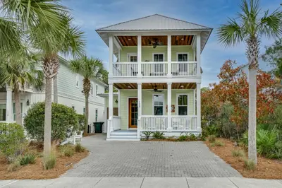 a white house with palm trees in front of it at 30A Blue Crab Cottage by Panhandle Getaways in Rosemary Beach