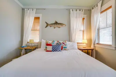 a bedroom with a bed with pillows and a fish on the wall at 30A Blue Crab Cottage by Panhandle Getaways in Rosemary Beach