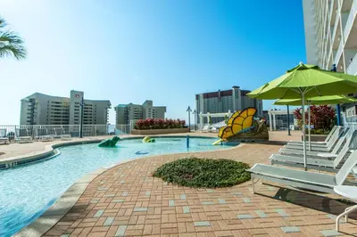a swimming pool with a slide and an umbrella at Laketown Wharf 2118 in Panama City Beach
