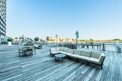 a couch on a boardwalk with tables and chairs at Laketown Wharf 2118 in Panama City Beach