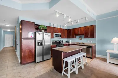 a kitchen with wooden cabinets and a stainless steel refrigerator at Laketown Wharf 2118 in Panama City Beach