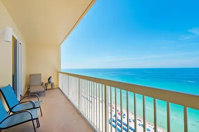 a balcony with chairs and a view of the ocean at Calypso 1-1809 East in Panama City Beach
