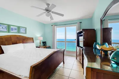 a bedroom with a bed and a view of the ocean at Calypso 1-1809 East in Panama City Beach