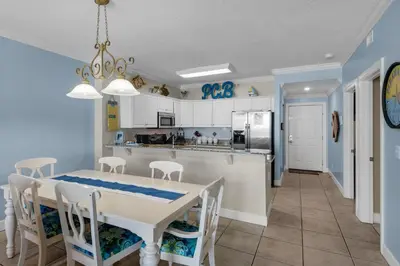 a kitchen and dining room with a table and chairs at Ocean Villa 405 in Panama City Beach