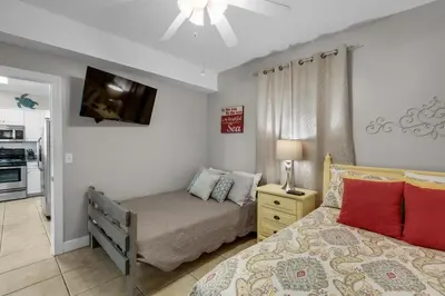 a small bedroom with a bed and a tv at Ocean Villa 405 in Panama City Beach