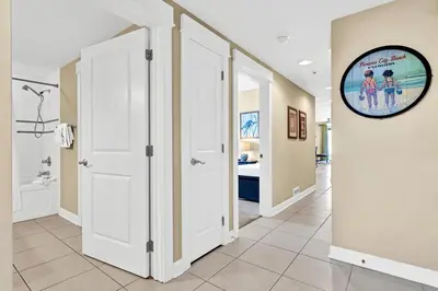 a hallway with white doors and a clock on the wall at Grand Panama 1-409 in Panama City Beach