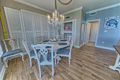 a dining room with a table and chairs and a chandelier at Cozy Oceanfront Condo with Beachside Pool - Unit 1602 in Panama City Beach