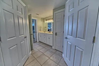 a hallway with two doors and a bathroom with a sink at Cozy Oceanfront Condo with Beachside Pool - Unit 1602 in Panama City Beach