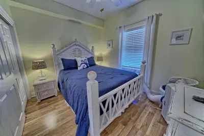 a bedroom with a bed with a blue comforter at Cozy Oceanfront Condo with Beachside Pool - Unit 1602 in Panama City Beach