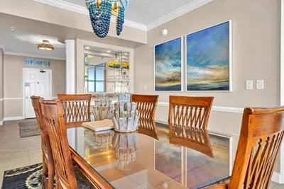 a dining room with a glass table and chairs at Hidden Dunes 1401 in Panama City Beach