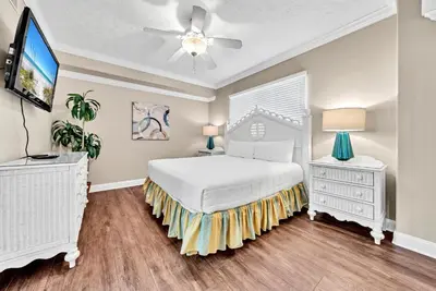 a bedroom with a white bed and a ceiling fan at Hidden Dunes 1401 in Panama City Beach