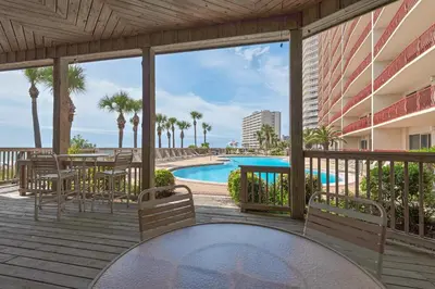 a balcony with a table and chairs and a pool at Hidden Dunes 1401 in Panama City Beach