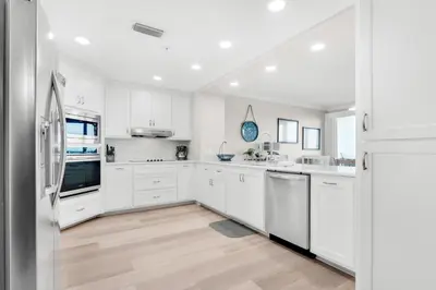 a kitchen with white cabinets and white appliances at Hidden Dunes 304 in Panama City Beach