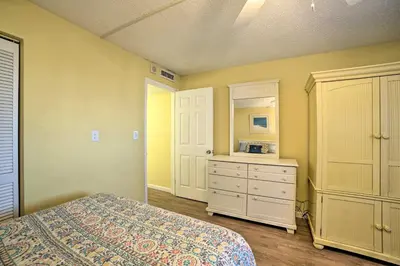 a bedroom with a bed and a dresser at Beachfront PCB Escape with Free Beach Chair Services in Panama City Beach