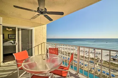 a balcony with a table and chairs and the beach at Beachfront PCB Escape with Free Beach Chair Services in Panama City Beach