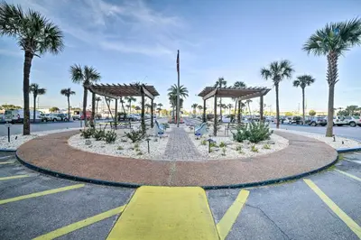 a large fountain in a parking lot with palm trees at Beachfront PCB Escape with Free Beach Chair Services in Panama City Beach