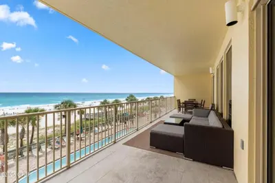 a balcony with a couch and a view of the beach at Astonishing Beacfront Condo with 360 sqft Balcony Facing the Ocean - Unit 0302 in Panama City Beach
