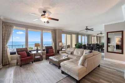 a living room with a couch and a ceiling fan at Astonishing Beacfront Condo with 360 sqft Balcony Facing the Ocean - Unit 0302 in Panama City Beach