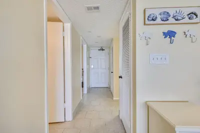 a hallway of a house with a white door and blue plates on the wall at Commodore Resort #707 by Book That Condo in Panama City Beach
