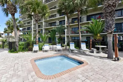 a resort with a swimming pool and chairs and a building at Commodore Resort #707 by Book That Condo in Panama City Beach