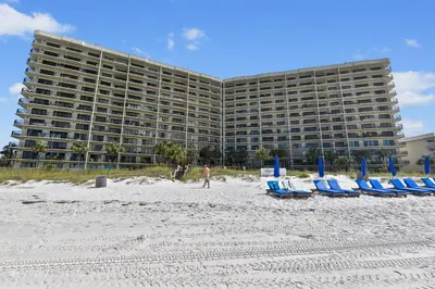 a group of beach chairs and a large building at Commodore Resort #707 by Book That Condo in Panama City Beach