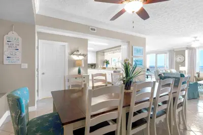 a dining room and living room with a table and chairs at Hidden Dunes 402 in Panama City Beach