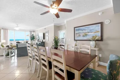 a dining room and living room with a table and chairs at Hidden Dunes 402 in Panama City Beach