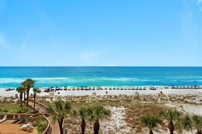 a view of a beach with palm trees and the ocean at Hidden Dunes 402 in Panama City Beach