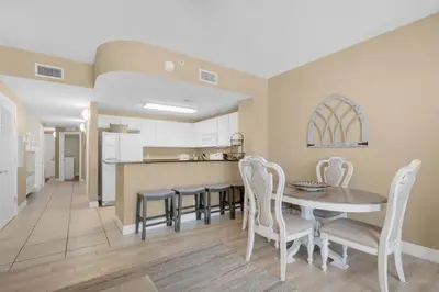 a kitchen and dining room with a table and chairs at Calypso 1-203 East in Panama City Beach