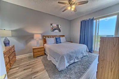 a bedroom with a bed and a ceiling fan at Spacious Tropical Condominium at 17th Floor with Beach and Pool Access - Unit 1707 in Panama City Beach