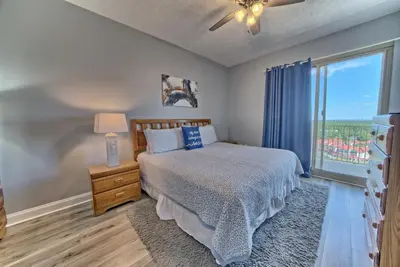 a bedroom with a bed and a large window at Spacious Tropical Condominium at 17th Floor with Beach and Pool Access - Unit 1707 in Panama City Beach