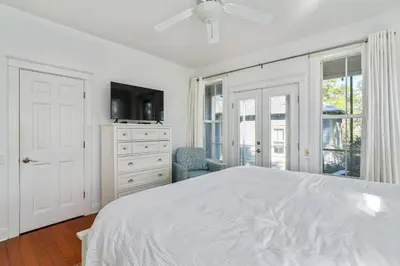 a white bedroom with a bed and a tv at Pure Joy* in Santa Rosa Beach
