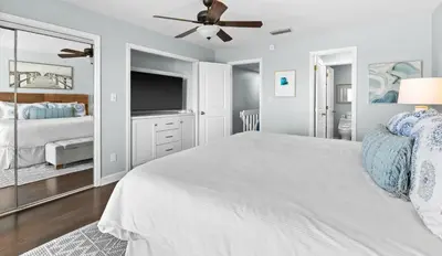a bedroom with a white bed and a flat screen tv at Silver Sands Townhomes Unit 4 in Inlet Beach