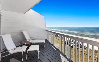 a balcony with two chairs and the ocean at Silver Sands Townhomes Unit 4 in Inlet Beach