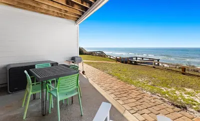 a patio with a table and chairs and the ocean at Silver Sands Townhomes Unit 4 in Inlet Beach