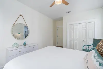 a white bedroom with a bed and a mirror at 248 Beach Bike Way in Inlet Beach
