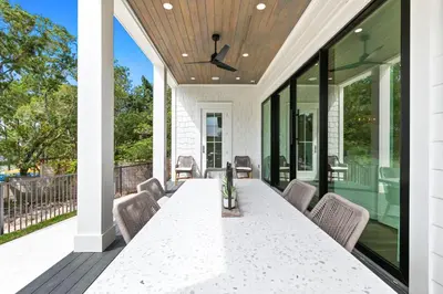 a dining table on a screened porch with glass doors at 169 Lakeview Drive in Santa Rosa Beach