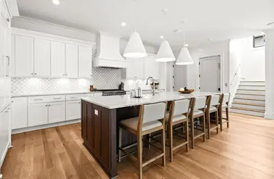 a kitchen with white cabinets and a large island with chairs at 169 Lakeview Drive in Santa Rosa Beach