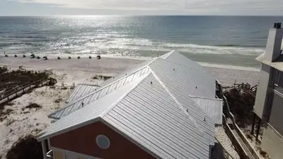 a building on the beach next to the ocean at Chivas Apartment on 30A in Santa Rosa Beach