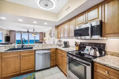 a kitchen with wooden cabinets and a stove top oven at Flipflop Paradise Unit 625 in Panama City Beach