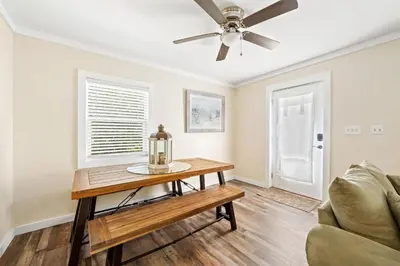 a living room with a table and a ceiling fan at Endless Summer's 514 in Panama City Beach