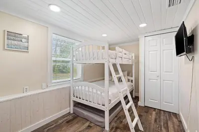 a white bunk bed in a room with a television at Endless Summer's 514 in Panama City Beach