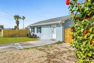 a blue house with a yellow fence in a yard at Endless Summer's 514 in Panama City Beach