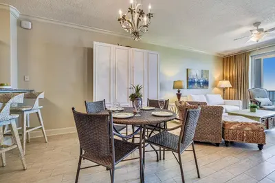 a dining room with a table and chairs and a living room at Twin Palms Resort #1404 by Book That Condo in Panama City Beach