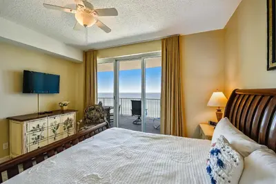 a bedroom with a bed and a view of the ocean at Twin Palms Resort #1404 by Book That Condo in Panama City Beach