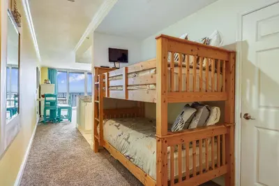 a bedroom with two bunk beds and a balcony at Emerald Beach #1426 by Book That Condo in Panama City Beach