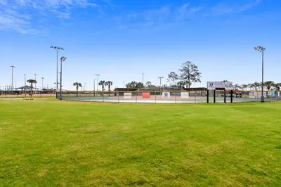 a baseball field with green grass and lights on it at Emerald Beach #1426 by Book That Condo in Panama City Beach